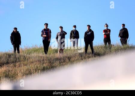 I fan si allontanano social mentre si sono riuniti su una collina che si affaccia sul terreno durante la prima partita della prima tappa della Sky Bet League due play-off al PTS Academy Stadium di Northampton. Foto Stock