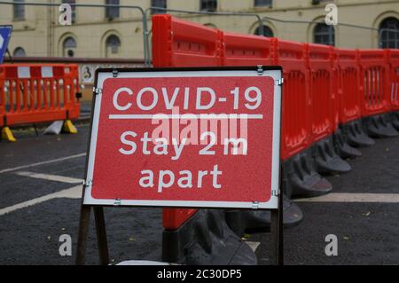 Coronavirus `sa 2 metri di distanza` cartello di avvertimento vicino ai lavori stradali sul ponte della città Foto Stock