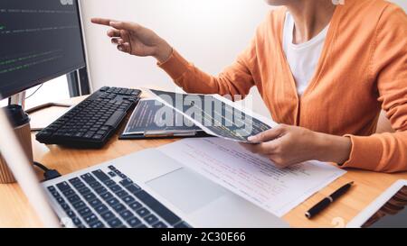 Programmatore pensieroso lavorando sul pc desktop codice di programmazione tecnologie o sito web design in ufficio azienda di sviluppo di software. Foto Stock