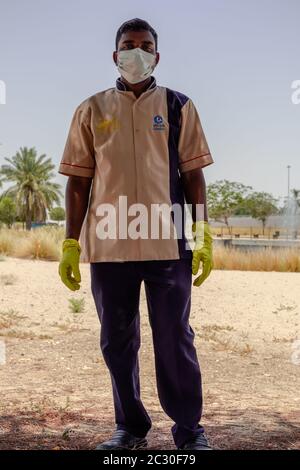 un giardiniere che indossa maschera facciale e guanti per le mani durante il lavoro, coronavirus - covid19 pandemic Foto Stock