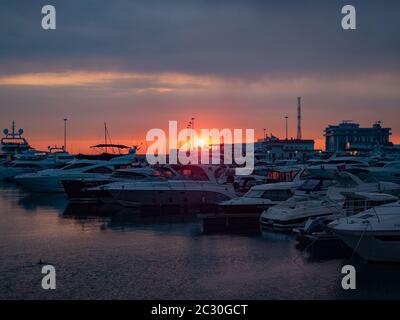 Russia, Sochi 03.10.2019. Molo di mare con yacht e barche a Sochi al tramonto Foto Stock