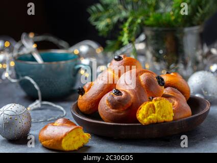 Culo con lo zafferano, un lussebullo svedese tradizionale o lussekatt. Foto Stock