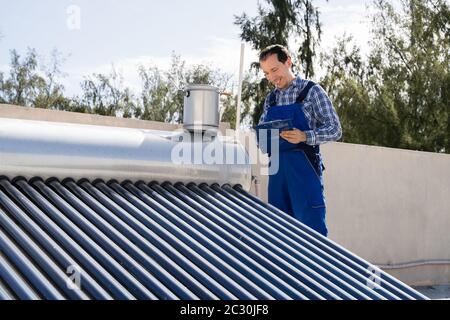 Idraulico Maschio Che Fa Energia Solare Caldaia Ispezione Foto Stock