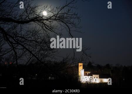 Super luna sopra il castello luminoso nel buio Foto Stock