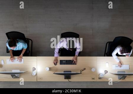 Ambiente di tarda notte, vista dall'alto del team degli operatori del call center con cuffie che lavorano in un call center, servizio clienti e supporto tecnico. Utilizzo di per Foto Stock