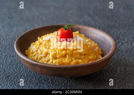 Porzione di risotto alla zucca decorata con pomodoro ciliegino Foto Stock