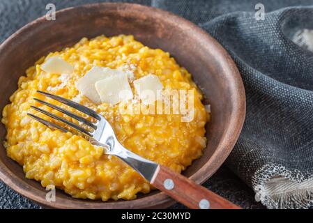 Porzione di risotto alla zucca decorata witn fette di parmigiano Foto Stock