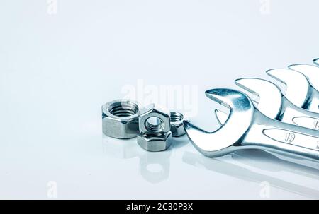 Metallo dadi esagonali e chrome chiavi isolati su sfondo bianco. Gli utensili meccanici per la manutenzione. Strumento hardware. Chiusura con un foro filettato. Impostare Foto Stock