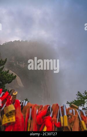 Tempio buddista coperta di nebbia e la nebbia come visto dalla vetta del Picco del Sud sulla montagna Huashan, Xian, Shaanxi Foto Stock