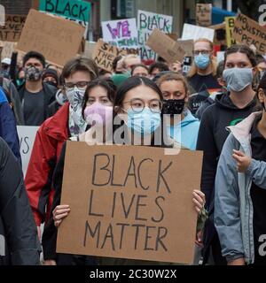 Molti portando segni, la gente marciano lungo una strada durante un 7 giugno 2020, Black Lives materia di protesta a Eugene, Oregon. Foto Stock