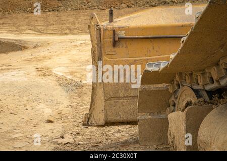 Escavatore riassume il suolo sul sito in costruzione nella stagione estiva Foto Stock