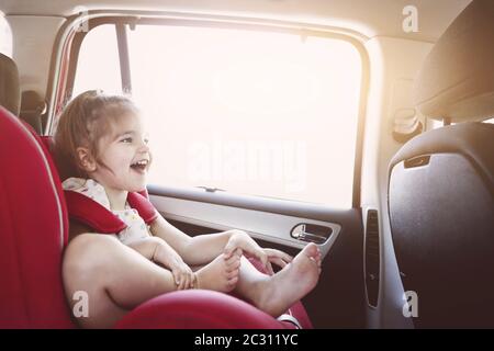 Carina bambina in auto sedile di sicurezza sorridente Foto Stock