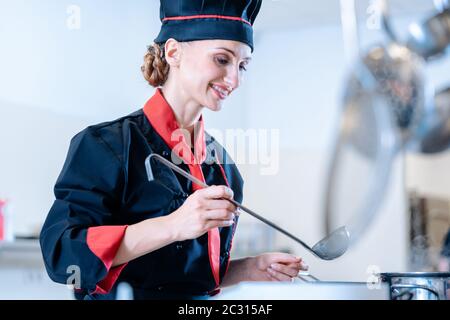 Una salsa femminile da chef con un mestolo Foto Stock