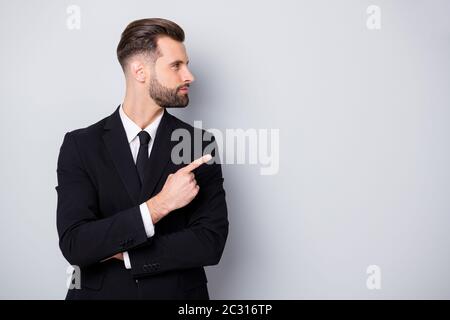 Profilo foto laterale di Smart confident uomo azienda proprietario punto indice dito copyspace modo diretto annunci promozione indossare nero formalwear abbigliamento isolato Foto Stock