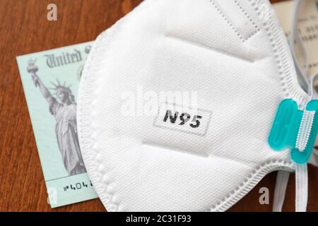 N95 maschera medica per il viso poggiata su IRS Covid-19 controllo economico di rilievo Foto Stock