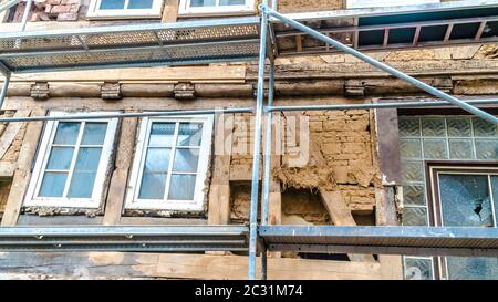 Impalcatura su una vecchia casa dilapidata a graticcio Foto Stock