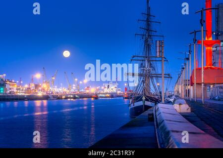 La nave alta ancorata a Dublino ormeggia sul fiume Liffey all'ora blu con luna piena Foto Stock