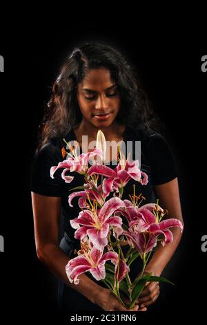 Donna che tiene fiori di giglio Foto Stock