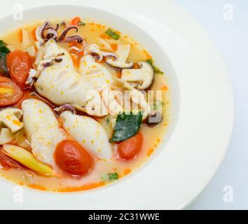 Calamari e limone con zuppa piccante con funghi, pomodori ed erbe Foto Stock