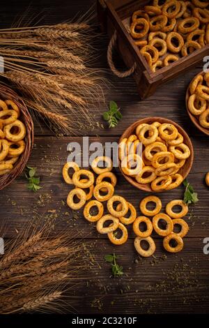 Posa piatta di anelli pretzel cracker salati su sfondo di legno scuro Foto Stock