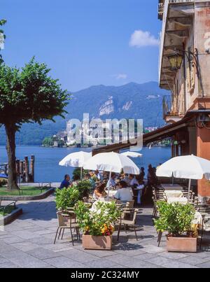 Ristorante sul lago con alle spalle l'Isola San Giulio, Orta San Giulio, Provincia di Novara, Regione Piemonte, Italia Foto Stock