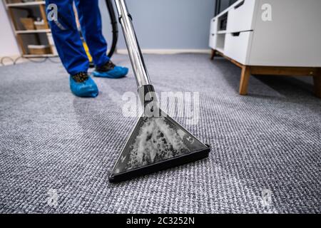 Close-up di un tappeto di pulizia con aspirapolvere Foto Stock