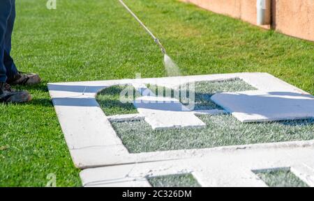 Disegnare lettere sull'erba in bianco su un modello. Il nome del campo di calcio sull'erba. Foto Stock