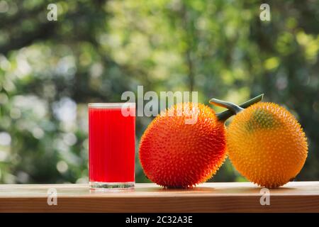 Baby Jackfruit, frutta GAC con succo di jackfruit su sfondo sfocato. Bevanda e concetto sano. Foto Stock