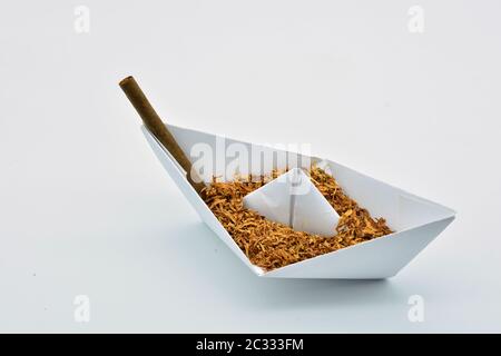 Barco de papel cargado de tabaco sobre fondo blanco Foto Stock