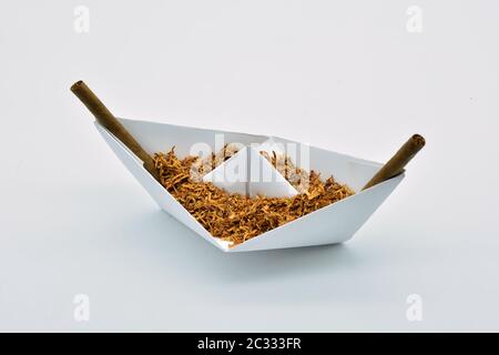 Barco de papel cargado de tabaco sobre fondo blanco Foto Stock