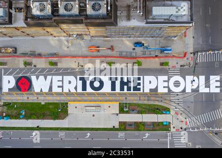 Detroit, Stati Uniti. 18 Giugno 2020. Detroit, Michigan - con il sostegno della città di Detroit, gli adolescenti dipinse 'IL POTERE AL POPOLO' sul centro di Woodward Avenue. Il progetto arriva tra settimane di proteste per la violenza della polizia e l'assassinio di George Floyd e di altri afroamericani. Credit: Jim West/Alamy Live News Foto Stock