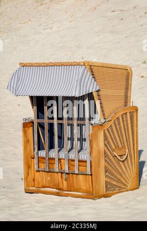 Una sedia da spiaggia chiusa si trova solo sulla spiaggia del Mar Baltico Foto Stock