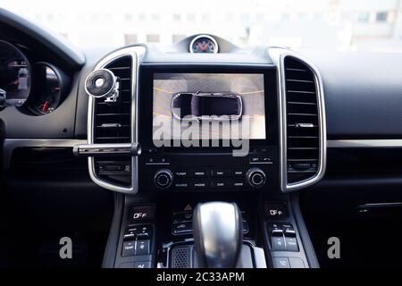Funzionamento di una telecamera di specchietto laterale per la vista posteriore. Del sistema di visione surround a 360 gradi. Visualizzazione delle immagini sull'unità principale. Multimedialità in auto. Assistenza per le opzioni all'interno di un'automobile premium Foto Stock