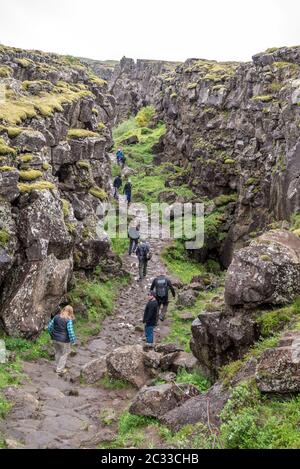 Thingvellir, Islanda - Luglio 19, 2017: i turisti a piedi attraverso il Almannagja linea anomalia nel mid-atlantic ridge Nord America placca a Thingvellir Na Foto Stock