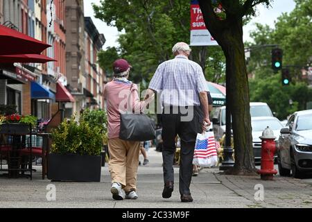 Hoboken, Stati Uniti. 18 Giugno 2020. Una coppia anziana cammina mano in mano mentre camminano lungo Washington St. A Hoboken, NJ, 18 giugno 2020. Dopo mesi di essere sotto la chiusura di COVID-19 per prevenire la diffusione del virus mortale, le nuove ordinanze della città stanno permettendo agli affari di usare lo spazio sul marciapiede per servire il pubblico dello shopping di ristoranti.(Anthony Behar/Sipa USA) Credit: Sipa USA/Alamy Live News Foto Stock