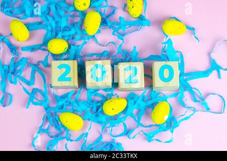 Parola Pasqua su cubetti di legno e circondato con molteplici decorazioni uovo come una festa di sfondo composizione pasquale. Foto Stock