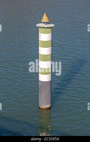 Verde e bianco pilastro di navigazione nel fiume Foto Stock