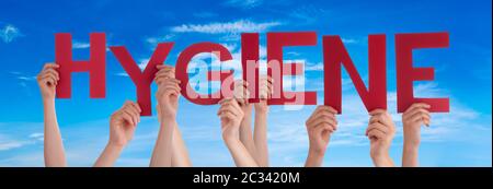 Persone mani tenuta Red English Word Hygiene. Cielo blu come sfondo Foto Stock