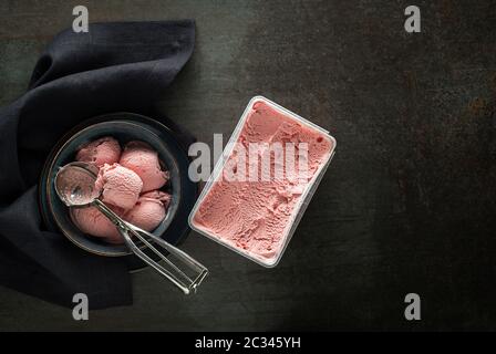 Fresco del gelato morbido o frozen yogurt con frutti di bosco sapori. Gelato di frutta sessole, raccolto fuori del contenitore con un utensile di argento Foto Stock