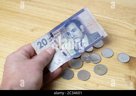 Un 20 Dirham banconota del Marocco con alcune monete sul tavolo Foto Stock