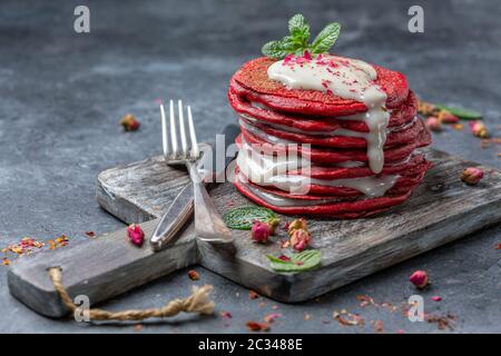 Deliziosi pancake di velluto rosso con salsa al formaggio cremoso. Foto Stock