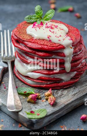 Frittelle di velluto rosso servite con salsa al formaggio cremoso. Foto Stock