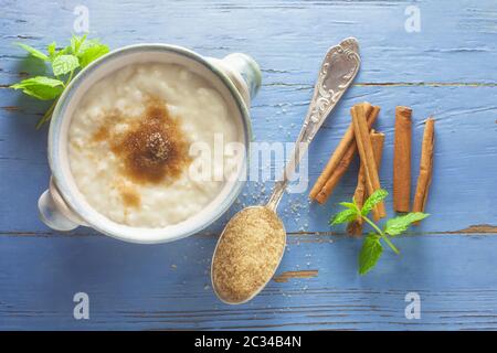 Budino di riso con zucchero e cannella su uno sfondo blu Foto Stock