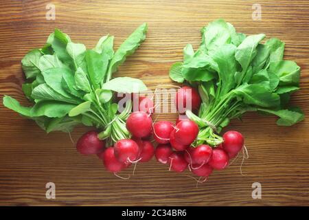 Due mazzetti di ravanelli su uno sfondo di legno Foto Stock