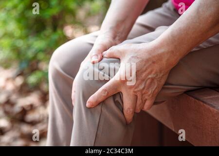 donna anziana che soffre di dolore alle gambe e al ginocchio Foto Stock