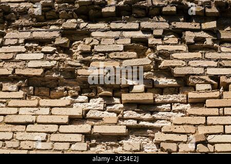 Vecchi mattoni di argilla arancio in un abbandonato rovinato edificio di mattoni rossi, rovine della fortezza in Europa Foto Stock