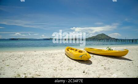 Due canoe gialle sulla spiaggia di sabbia. Indonesia. Kanawa. Foto Stock