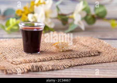 Prendere il concetto di comunione - il vino e i simboli del pane di Gesù Cristo sangue e corpo. Pasqua Pasqua e Signore . Concentrarsi sul vetro. Foto Stock