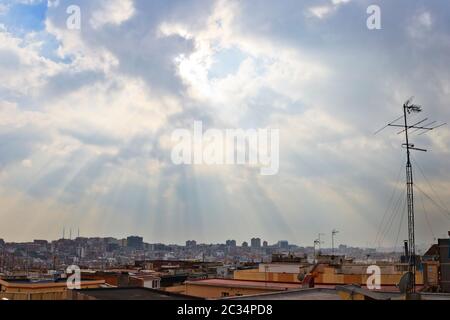 Raggi del sole attraverso le nuvole sui tetti di Santa Coloma de Gramenet, Barcellona, Spagna Foto Stock