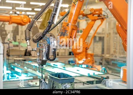 braccio robotico per la produzione automatizzata di componenti per l'industria automobilistica. Foto Stock